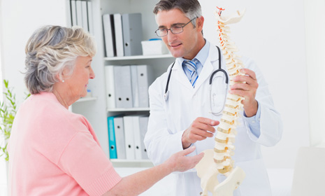 Doctor showing spine model to patient