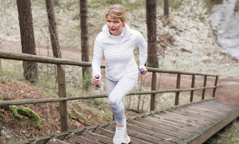 Person jogging up wooden stairs outdoors